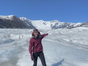 A hiker points across the Root Glacier toward the Stairway Icefall  Photo